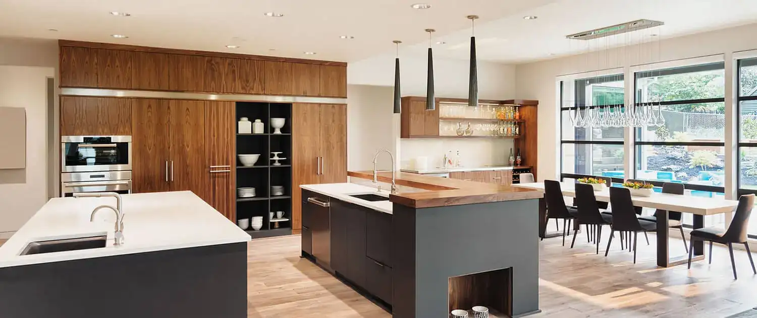 Walnut and stone kitchen completed by Manttan Construction, with island bench and dining area