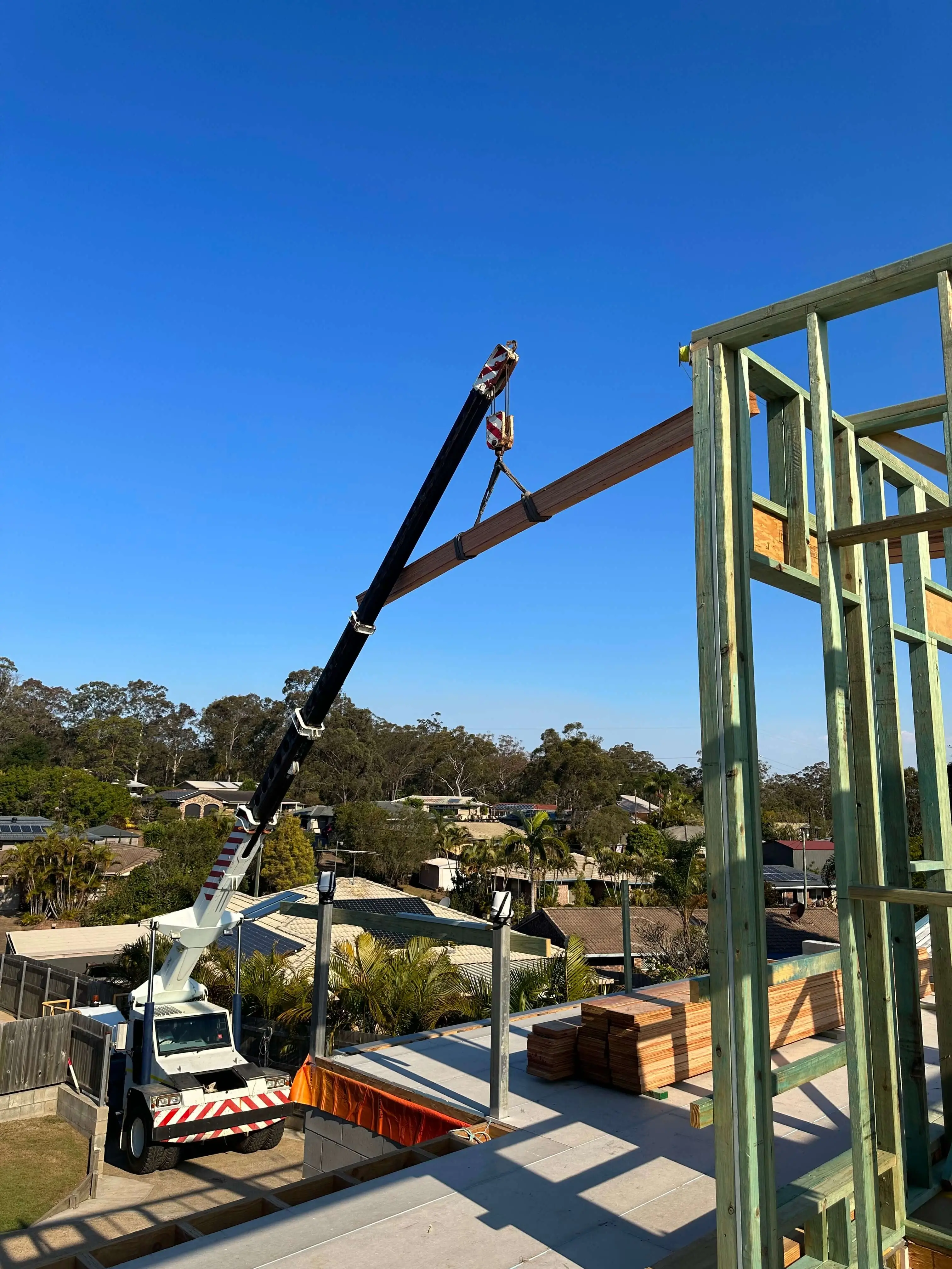 Franna crane lifting an LVL beam onto a new upper-floor wall frame, Brisbane