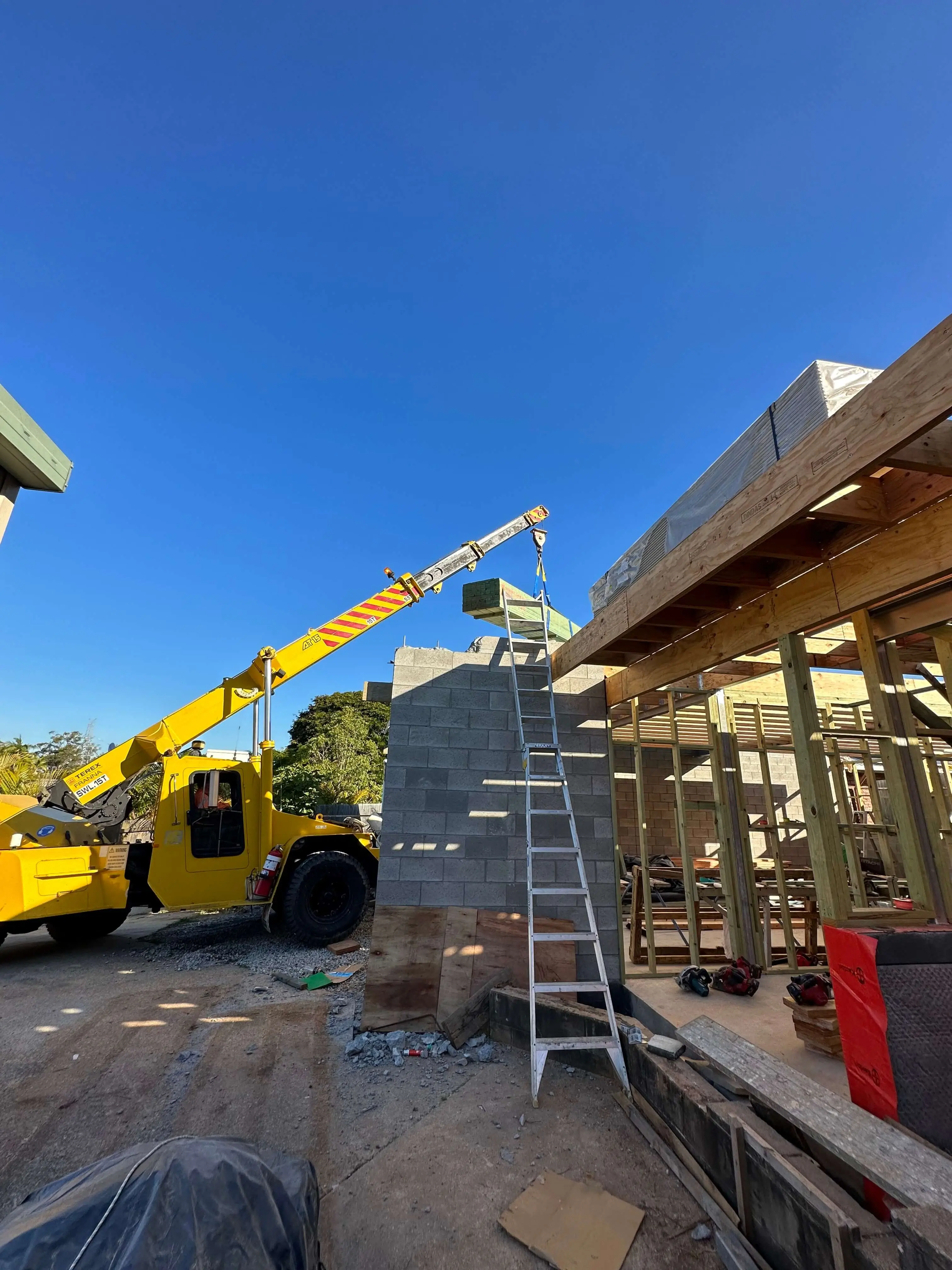 Crane lifting timber onto a two storey build in Brisbane