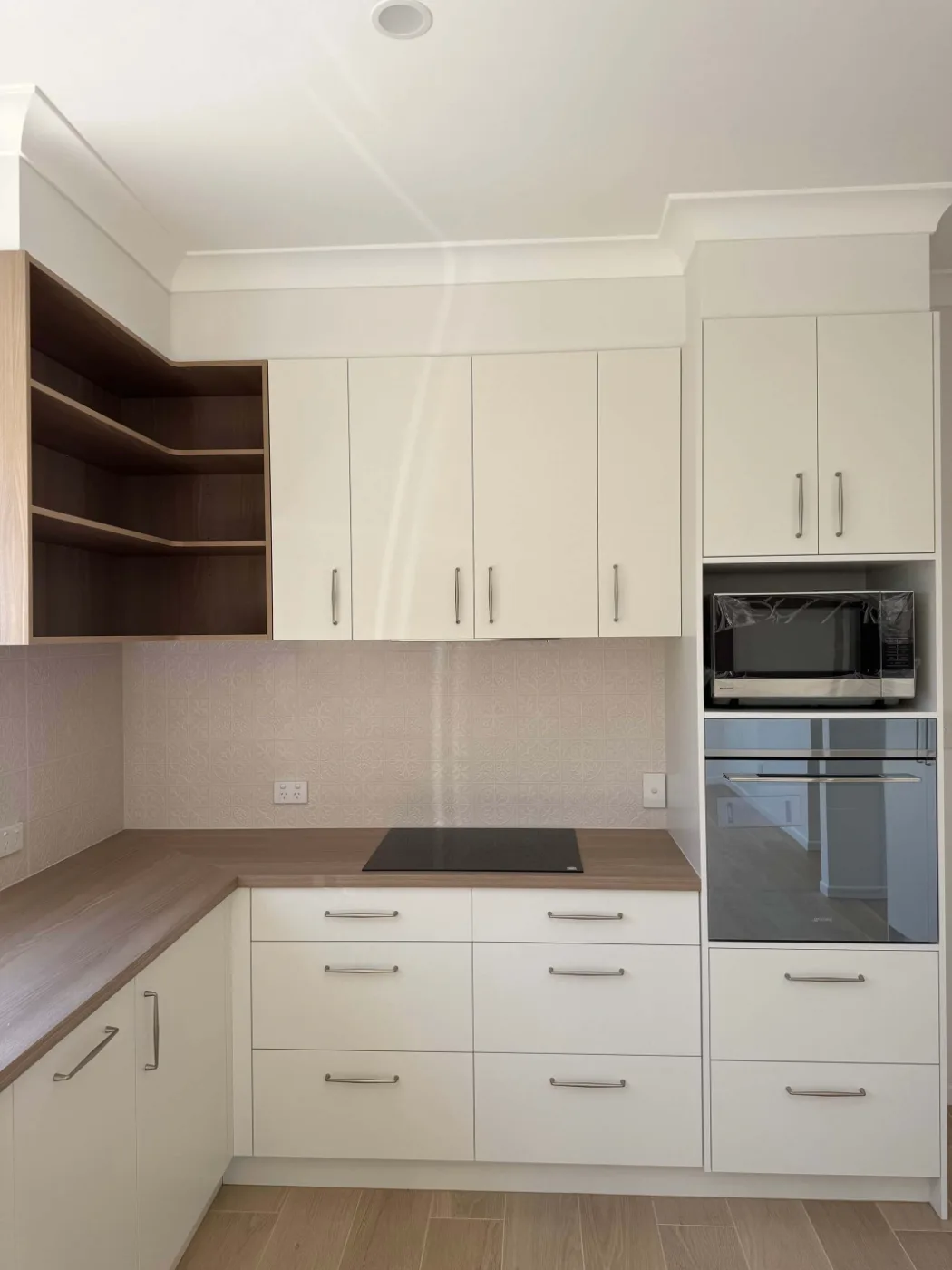 Kitchen cabinetry with patterned tile splashback and cooktop, Brisbane renovation