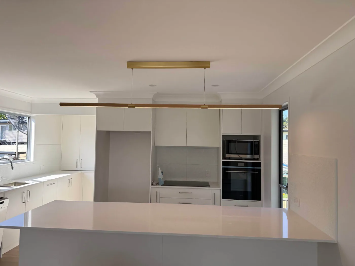 Kitchen renovation with white cabinetry and a stone island bench, Brisbane