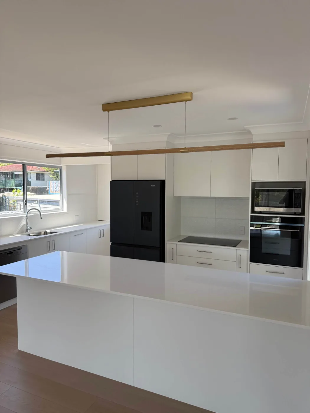 Open-plan kitchen with large island and integrated appliances, Brisbane home renovation