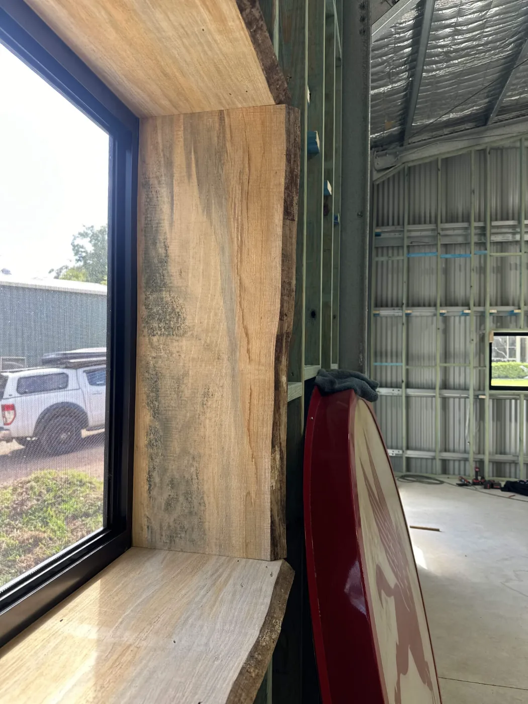 Live-edge hardwood window reveal and sill fitted during a man cave fit-out