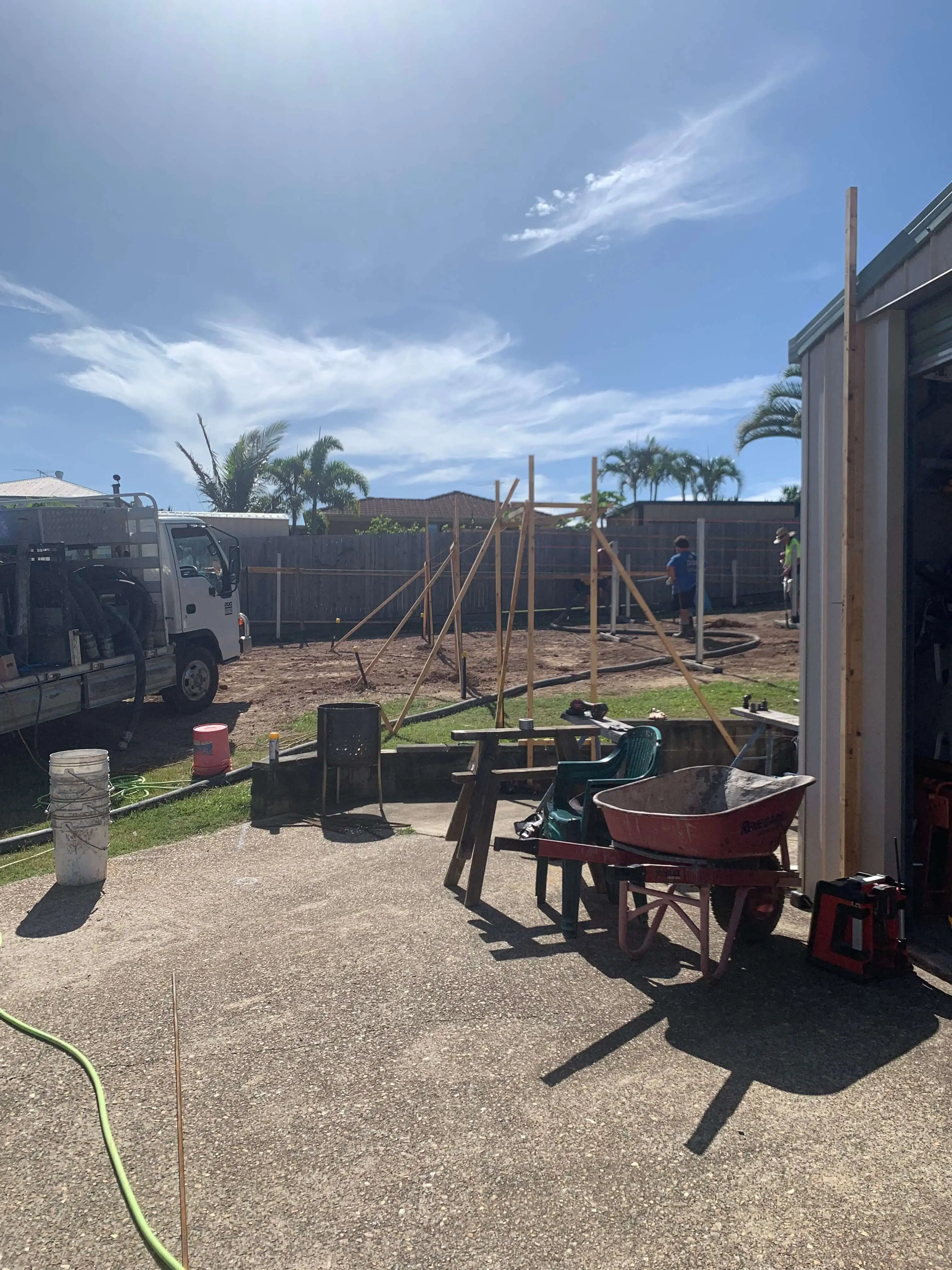 Backyard setout with profiles and string lines before footings, concrete truck on site