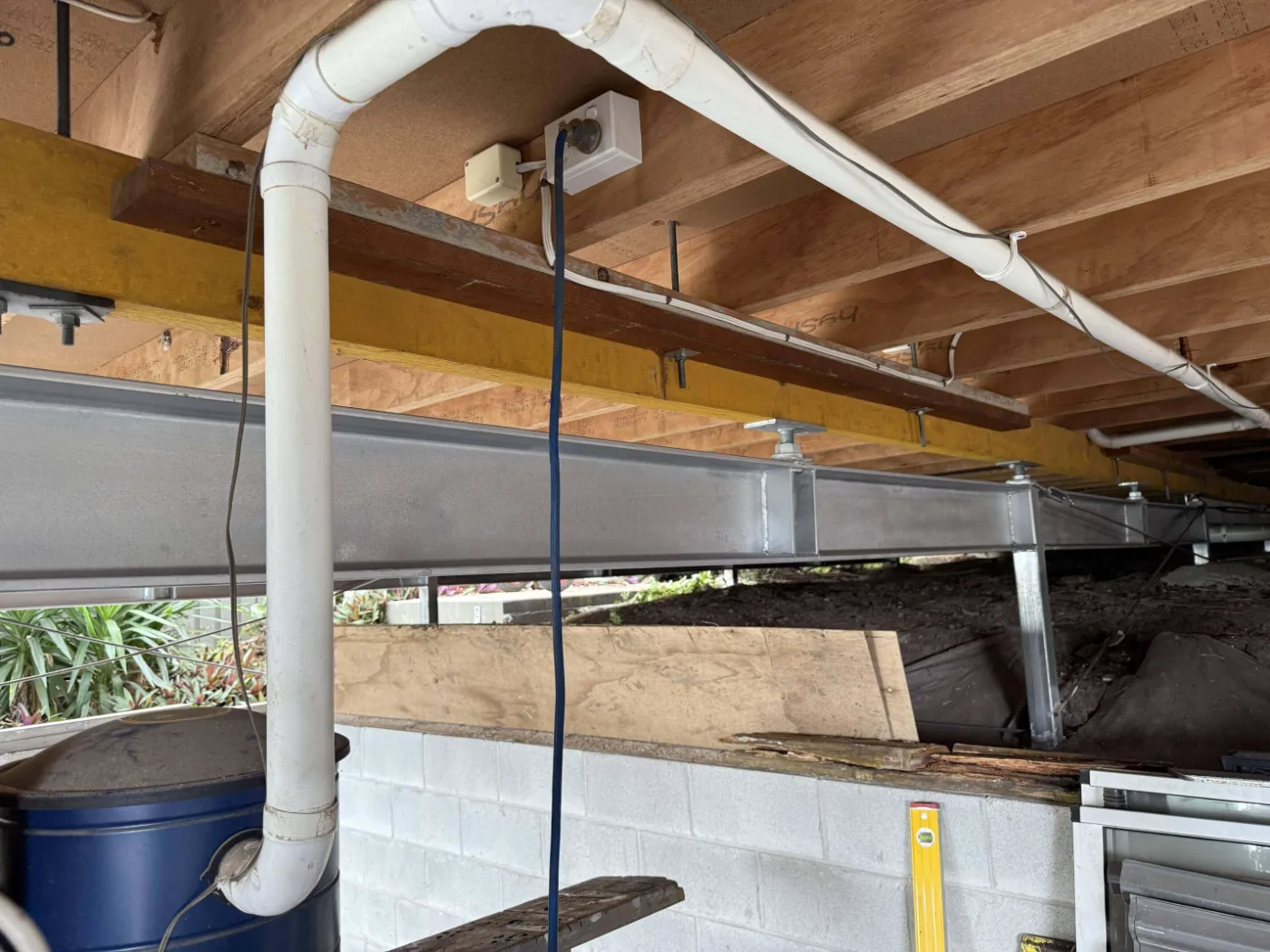 Steel beam and timber joists in a subfloor during structural repairs, Brisbane