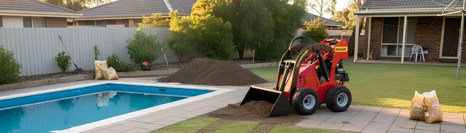 A small red mini loader moves a pile of soil near a backyard swimming pool, with bags of landscaping materials nearby and houses in the background. Builders Bayside Brisbane, Home Renovations Redlands